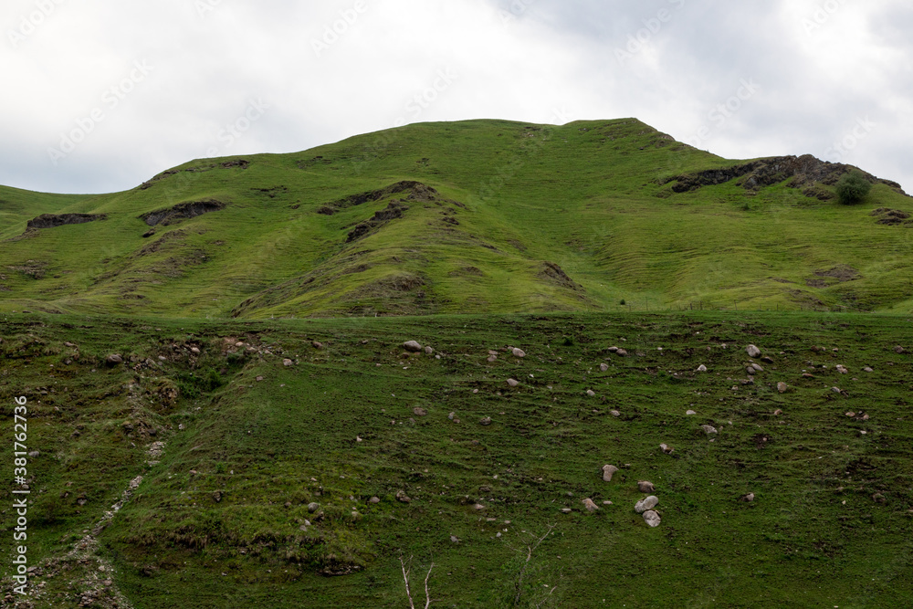 Fototapeta premium Mountain landscape with blue sky. Panoramic view of green hills.