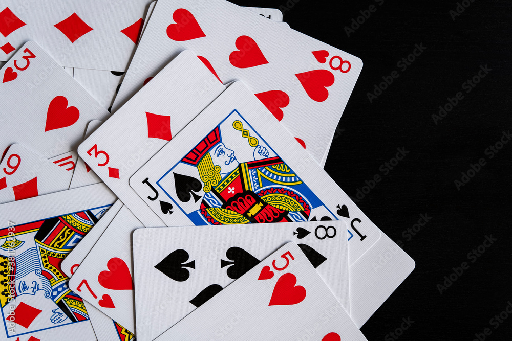 Mixed playing cards on a black table Mixed playing cards on a black table