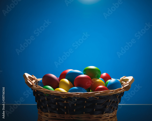 Easter color eggs in festive gift basket  blue background