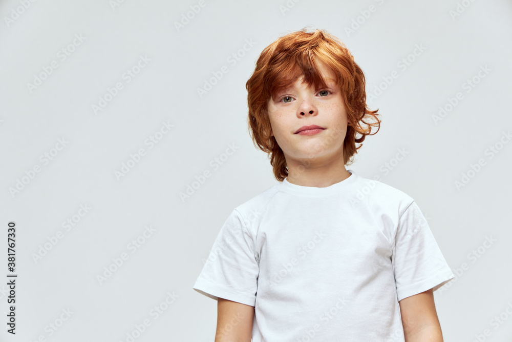 cute red-haired boy with freckles on his face white t-shirt cropped view studio cute red-haired boy with freckles on his face white t-shirt cropped view studio
