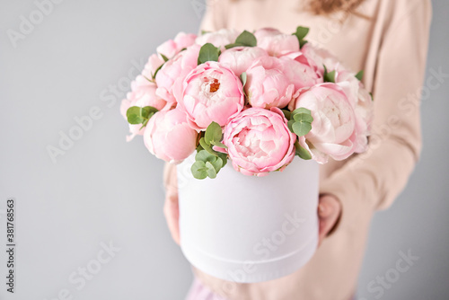 Fototapeta Naklejka Na Ścianę i Meble -  Round box with Bouquet of Pink peonies in a women hand. Beautiful peony flower for catalog or online store. Floral shop concept . Beautiful fresh cut bouquet. Flowers delivery