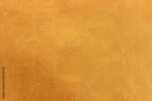 Gold or yellow paint on cement wall texture or background