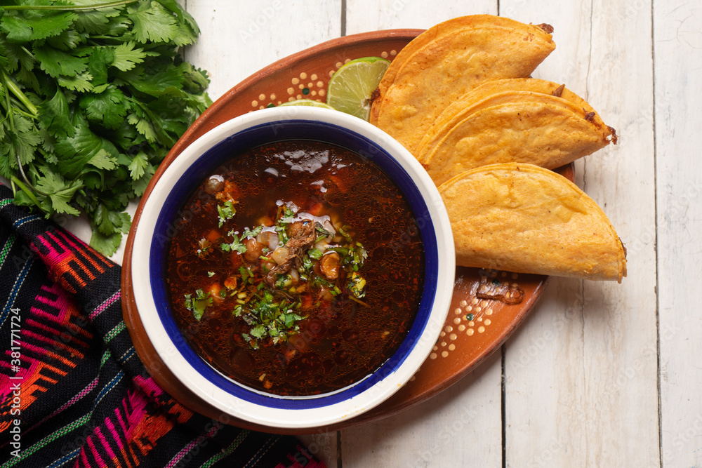 Mexican birria consome soup and tacos on white background Stock Photo