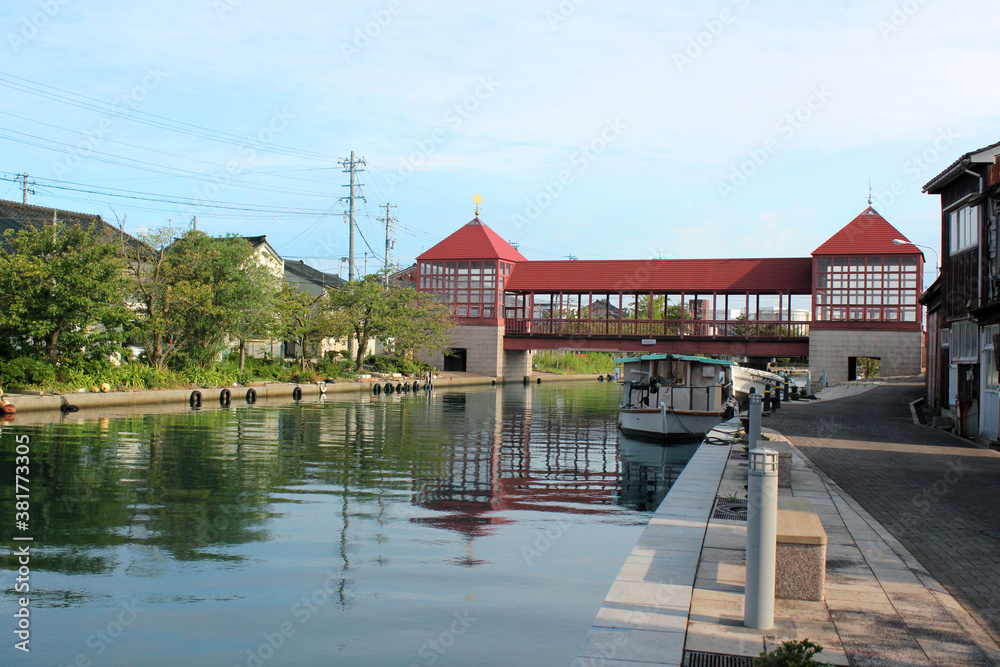 Obraz premium 晴れた日の木造のレトロな赤い橋と穏やかな川