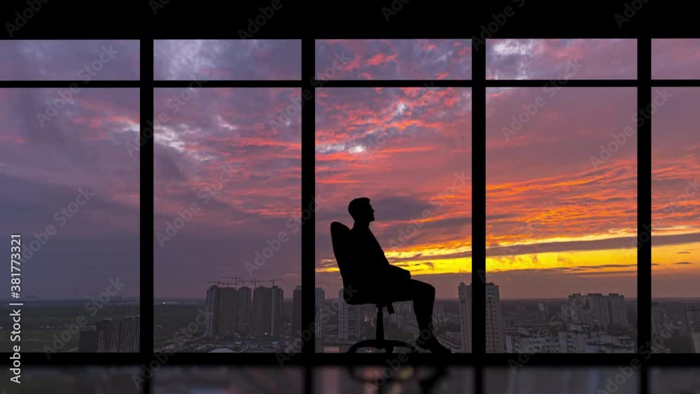 The man sitting in the chair against the morning city background. time lapse The man sitting in the chair against the morning city background. time lapse