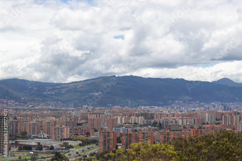 Amazing capture of a city landscape with modern residential buildings, mountains and blue cloudy sky at background. Metropoli and urban concept