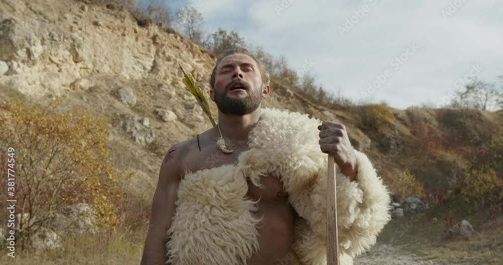 A wild nomadic man smells food while hunting with wildlife bows himself.