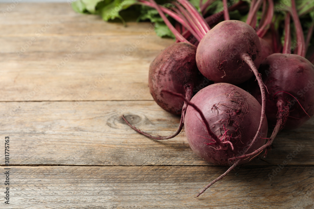 Raw ripe beets on wooden table. Space for text