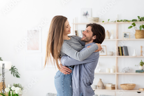 Beautiful man and woman embracing and having fun at home