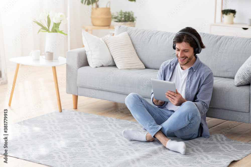 Happy young man using wireless headset and digital tablet Happy young man using wireless headset and digital tablet