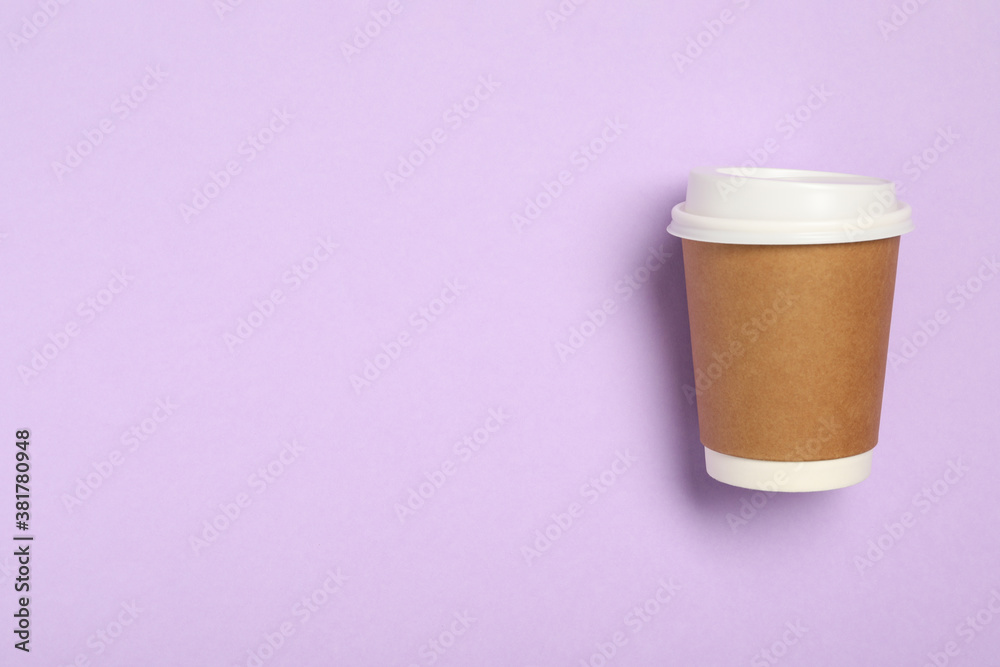 Takeaway paper coffee cup on violet background, top view. Space for text
