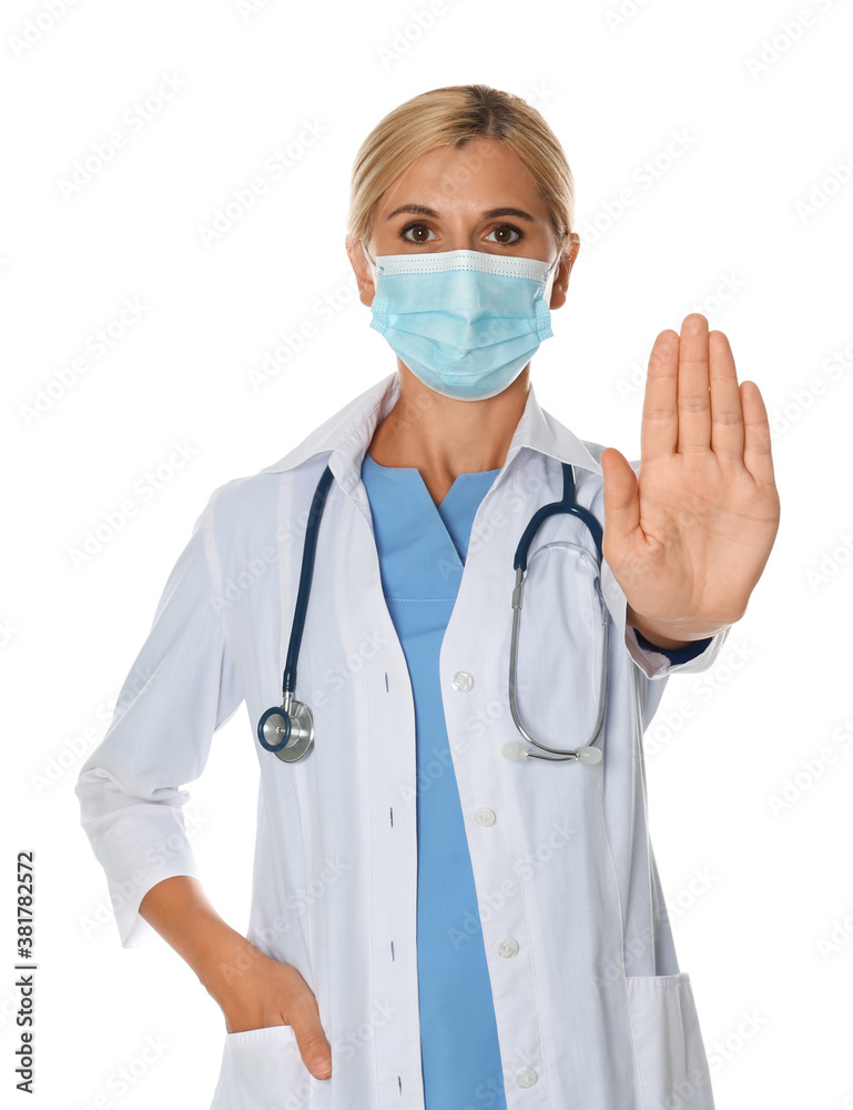 Doctor in protective mask showing stop gesture on white background. Prevent spreading of coronavirus Doctor in protective mask showing stop gesture on white background. Prevent spreading of coronavirus