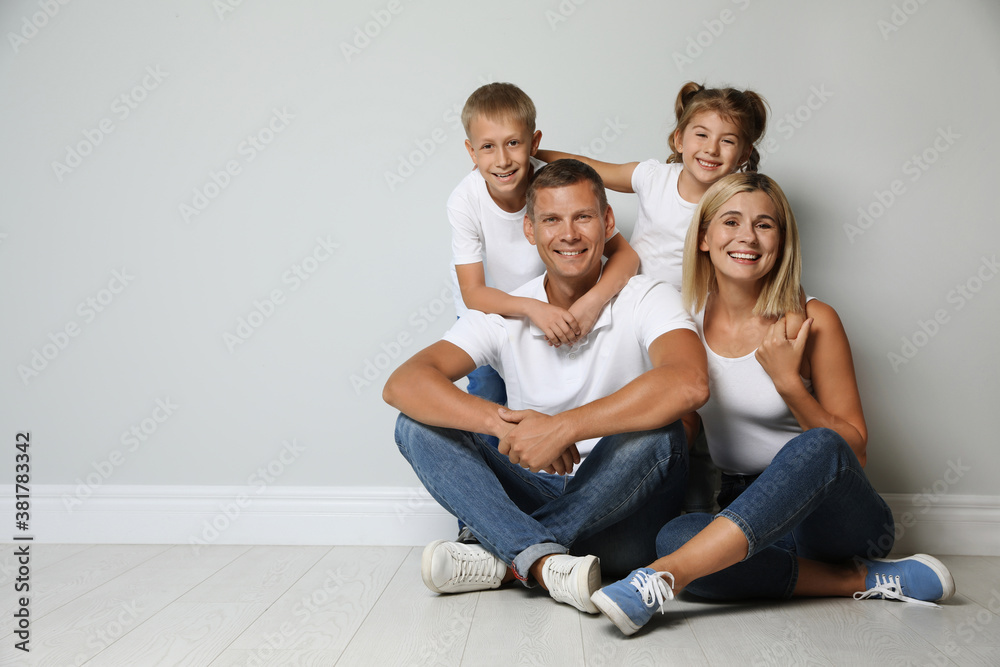 Happy family with children near grey wall. Space for text Happy family with children near grey wall. Space for text