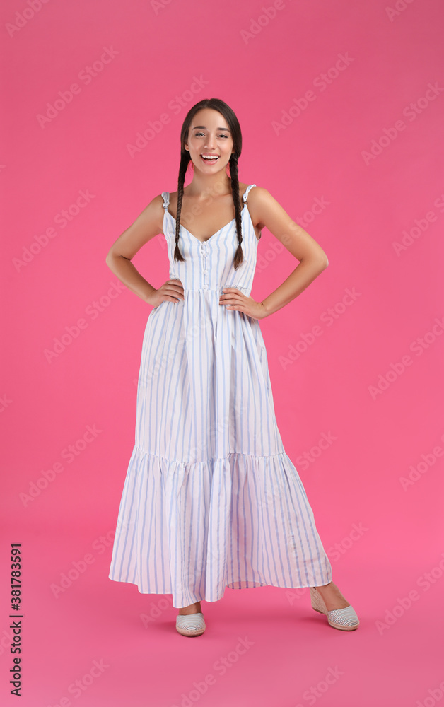 Young woman wearing stylish dress on pink background