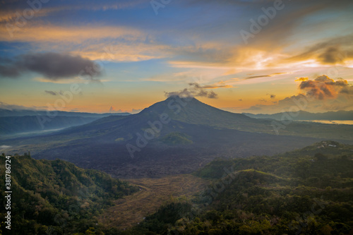 Beautiful mountain landscape during sunrise. Hills, Batur volcano and lake. Scenic panoramic view. Colorful sky with clouds. Foggy morning. Kintamani, Bali © Olga