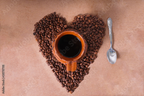 Heart made of coffee beans with a clay jar in the center