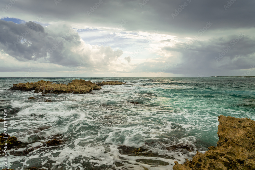 Wind, clouds, sky and choppy sea crashing at the rocks in the emerald Caribbean Sea Wind, clouds, sky and choppy sea crashing at the rocks in the emerald Caribbean Sea