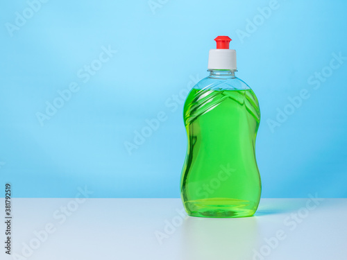 Foto A bottle of green cleaning gel on a white table on a blue background
