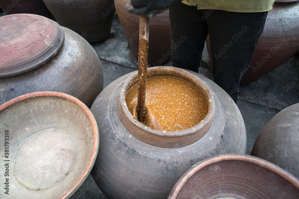 Fototapeta premium Jars of processing soybean jam made by traditional outdoor way under natural sunlight