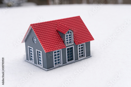 A small house model on white snow background