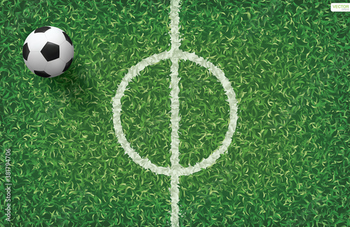 Soccer football ball on green grass of soccer field with center line area. Vector.