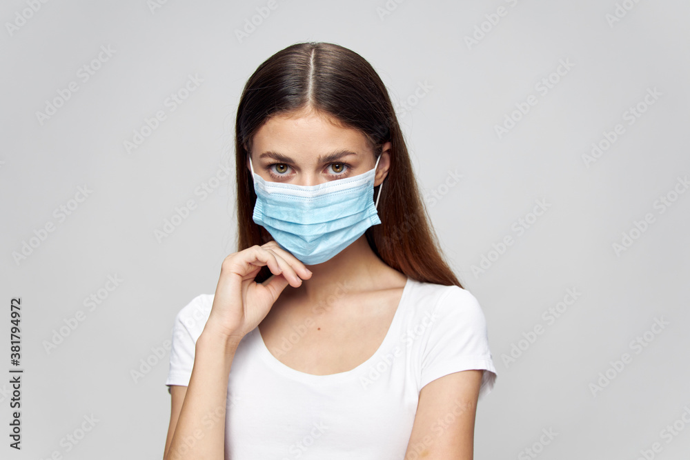 Pretty woman Medical mask on face look ahead white t-shirt protection Pretty woman Medical mask on face look ahead white t-shirt protection