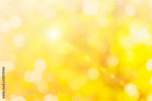 Natural yellow background blurring warm colors and bright gold sunlight. Bokeh or Christmas background at sky sunny color orange light patterns plain abstract flare evening clouds blur.