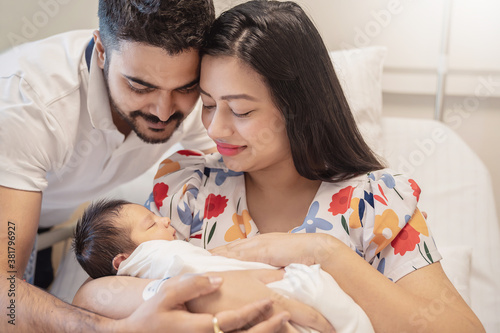 Asian parents with newborn baby, Closeup portrait of asian young couple father mother holding new born baby in hospital bed. Happy asia lovely family, nursery breastfeeding mother’s day concept photo