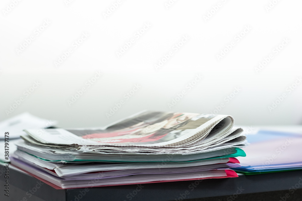 A stack of newspapers on the office table. Free space in the background for text. Latest news A stack of newspapers on the office table. Free space in the background for text. Latest news