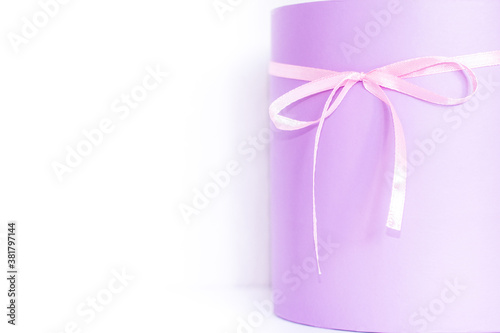 Festive purple box with a bow on the table. Content for congratulations. partial focus
