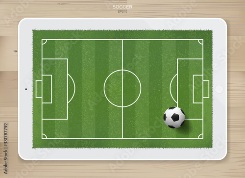 Soccer football ball in soccer field area on tablet display with wood texture background. For create soccer game and soccer football tactic idea. Vector.