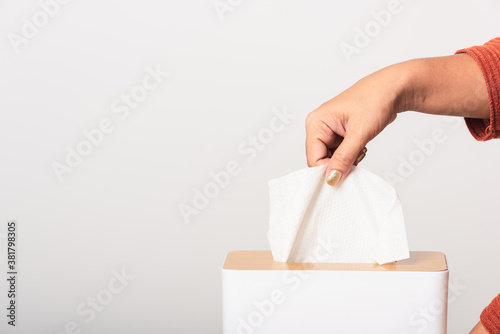 Foto Young woman flu she using hand taking pulling white facial tissue out of from a