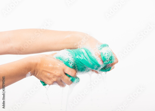 Female squeeze wring out wet fabric cloth with detergent have soapy bubble in water