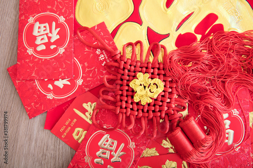 Chinese New Year red envelopes and spring couplets and a Chinese knot ornament.The Chinese characters on Chinese knots and spring couplets and red envelopes mean  happiness 