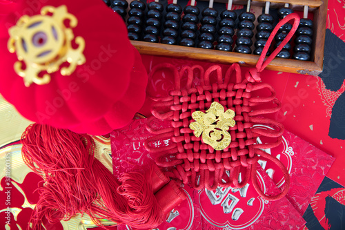 Looking down on Chinese knots and red envelopes, abacus and small lanterns on the table.The Chinese character on the Chinese knot means "happiness"