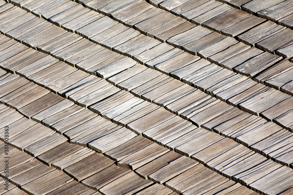 Elevated view of traditional wooden shingle roof with a few damaged shakes Elevated view of traditional wooden shingle roof with a few damaged shakes
