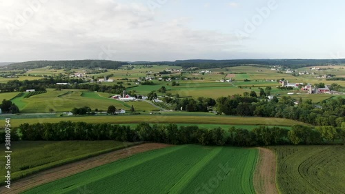 Quintessential Lancaster County PA Pennsyvlania, USA farmland aerial rising shot. Green fields and contoured fields make beautiful pattern. Summer magic hour perspective. photo