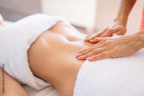 Woman make a belly massage in light procedure room. Anti-cellulite massage, diastasis. Faces are not recognizable
