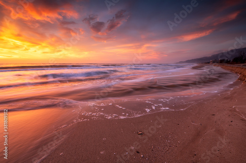 Amazing view with colorful reflections on the beach at sunrise
