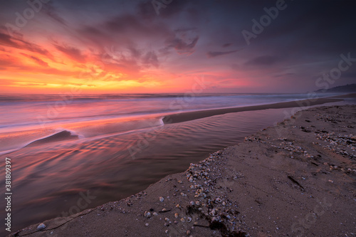 Amazing view with colorful reflections on the beach at sunrise