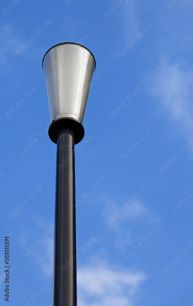 a cone-shaped lamppost against blue summer sky a cone-shaped lamppost against blue summer sky