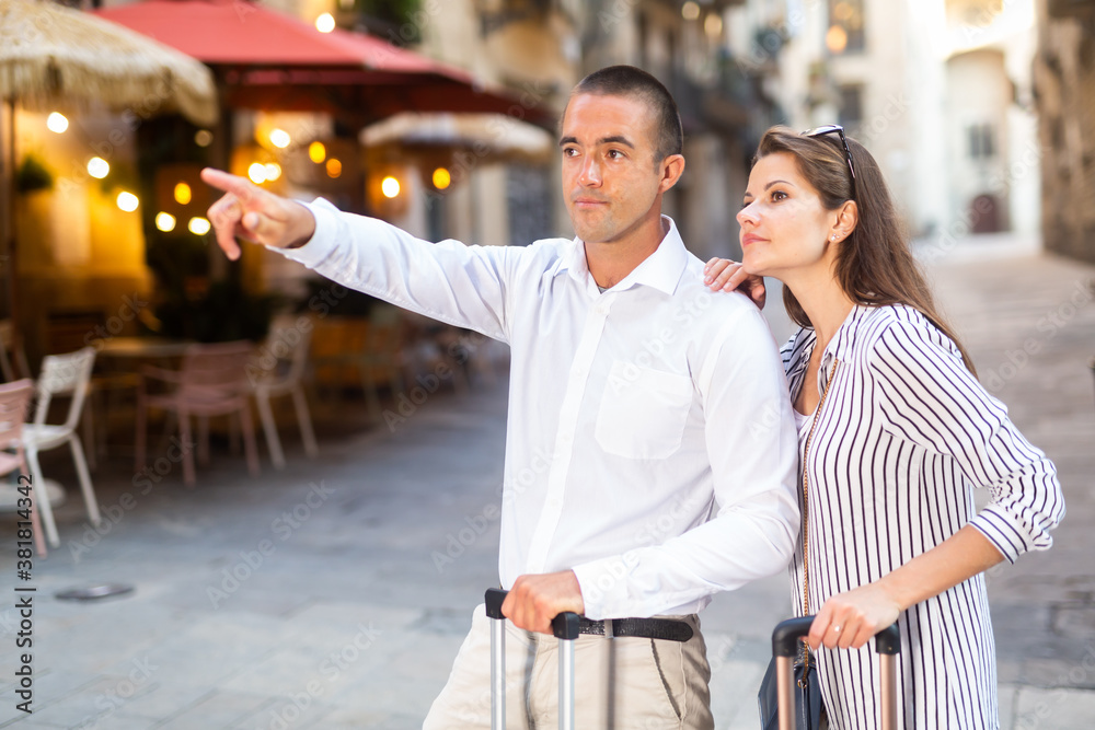 Elegant young couple of tourists admiring city views while traveling together