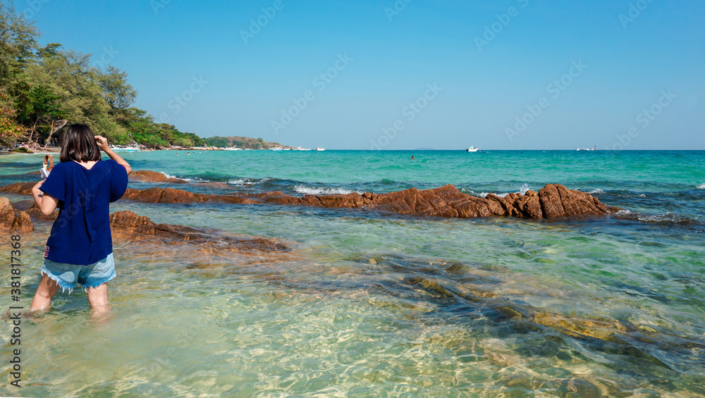 Asian woman with clearly sea water and blue sky background