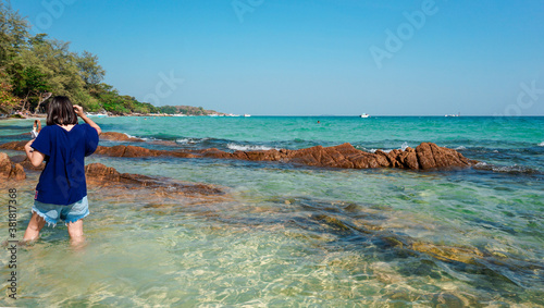 Asian woman with clearly sea water and blue sky background