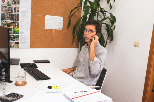 A young male architect working on a project in his office in Lisbon, Portugal. Young man working smart using the desktop computer while working on interior design project in his studio photo