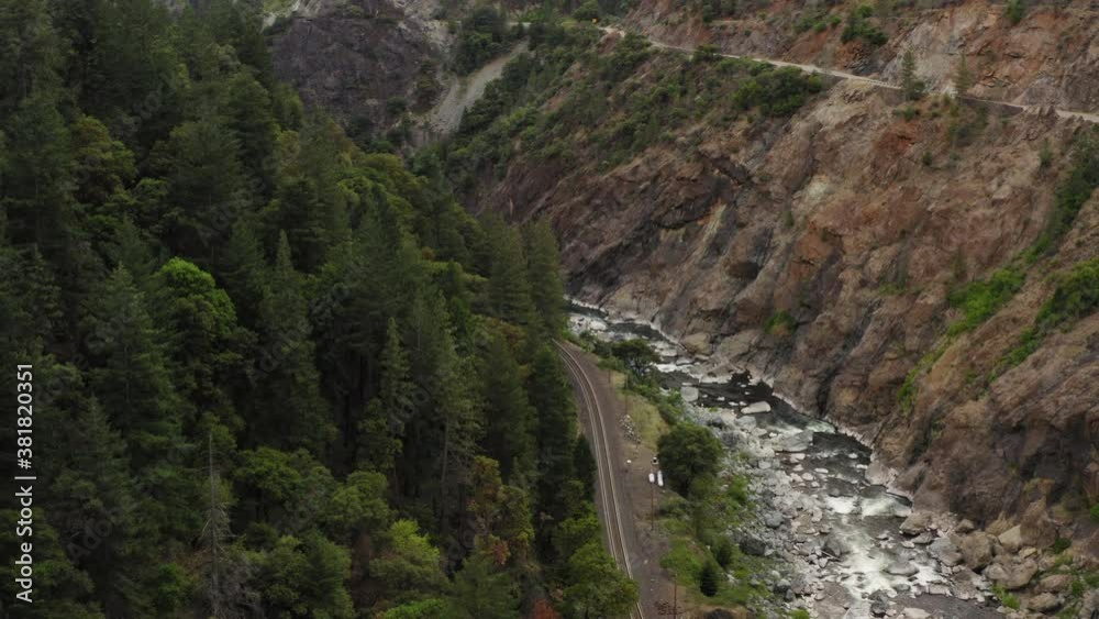 Drone pull back view going over an extremely tall metal bridge spanning another smaller bridge and a river. Cars pass on bridge. Drone pull back view going over an extremely tall metal bridge spanning another smaller bridge and a river. Cars pass on bridge.