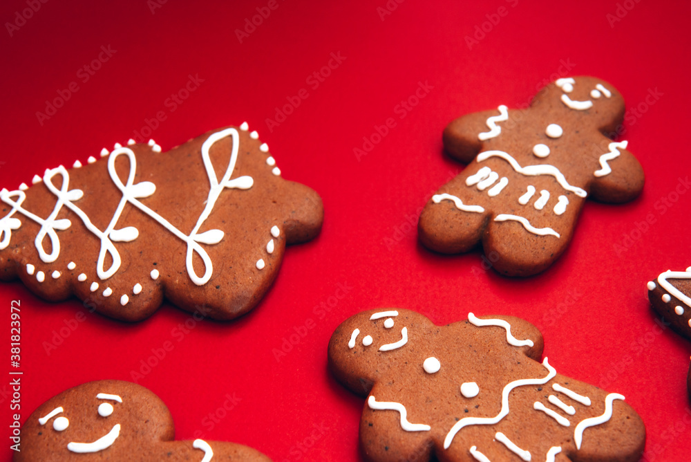 Tasty homemade Christmas gingerbread cookies of various shapes with sugar glaze on a bright festive red background. Merry Christmas card. Concept of celebrating new year. Christmas mood Tasty homemade Christmas gingerbread cookies of various shapes with sugar glaze on a bright festive red background. Merry Christmas card. Concept of celebrating new year. Christmas mood