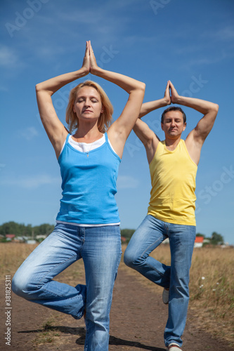 middle-aged people in yoga © yanlev