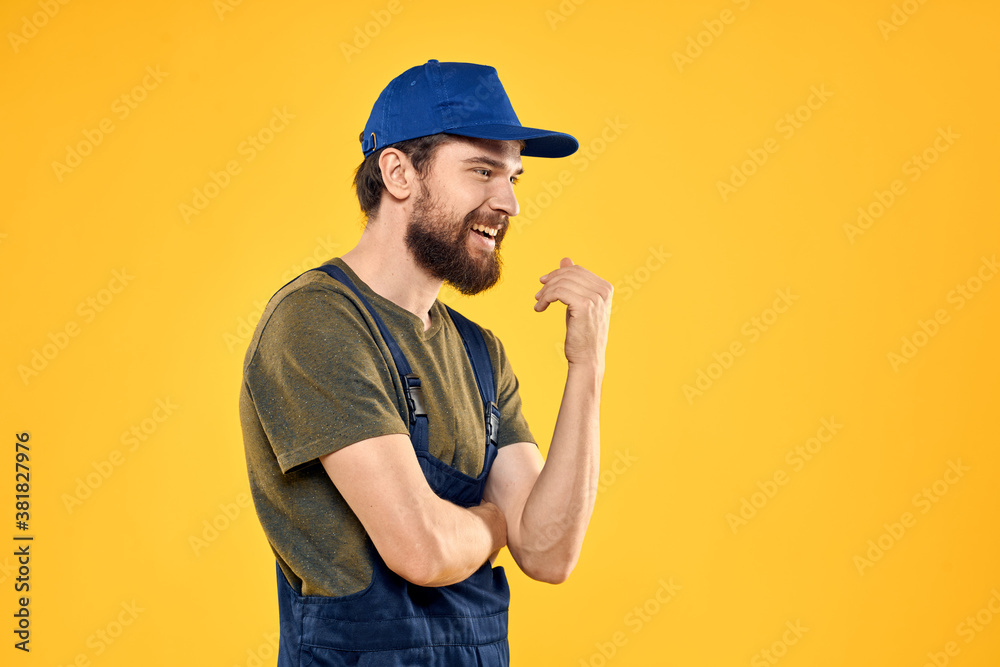 Worker man in uniform worker service yellow background emotion Worker man in uniform worker service yellow background emotion