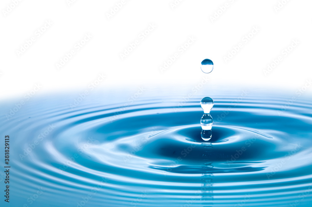 Water droplets fall down closely into the dark blue water, making it the perfect center in nature. Isolated on white background Water droplets fall down closely into the dark blue water, making it the perfect center in nature. Isolated on white background